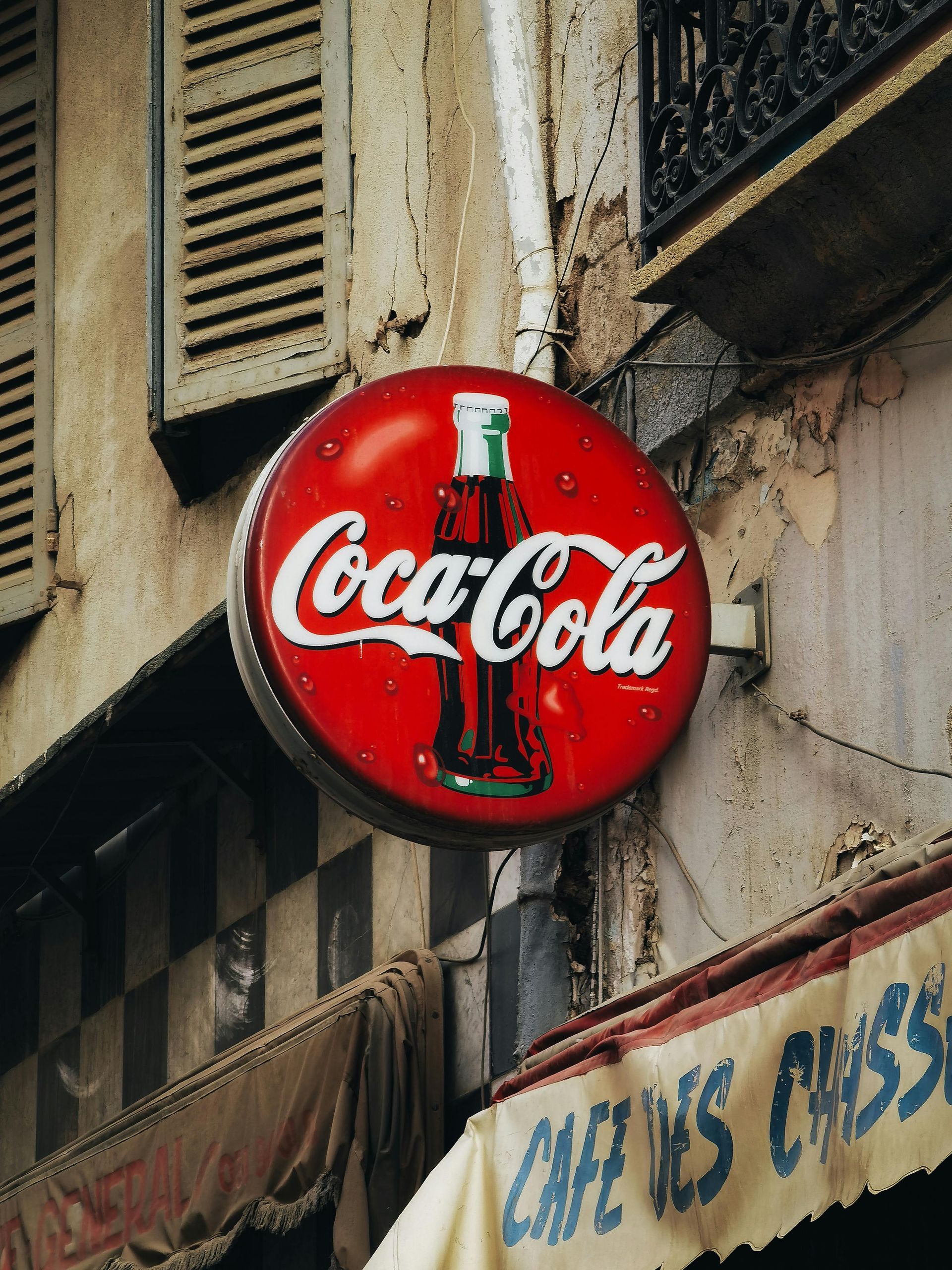 A coca cola sign hangs on the side of a building