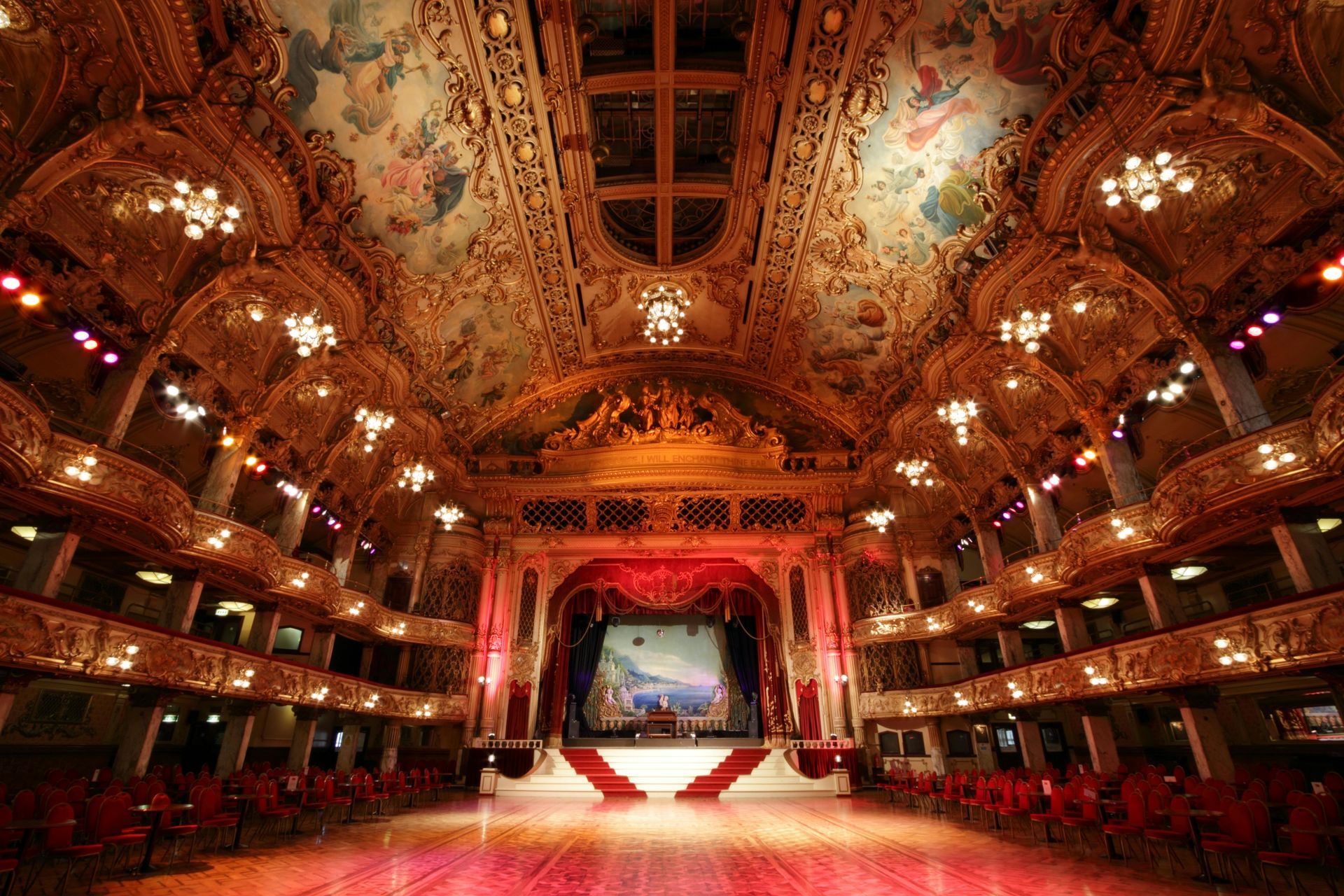 A large auditorium with a dance floor and a stage