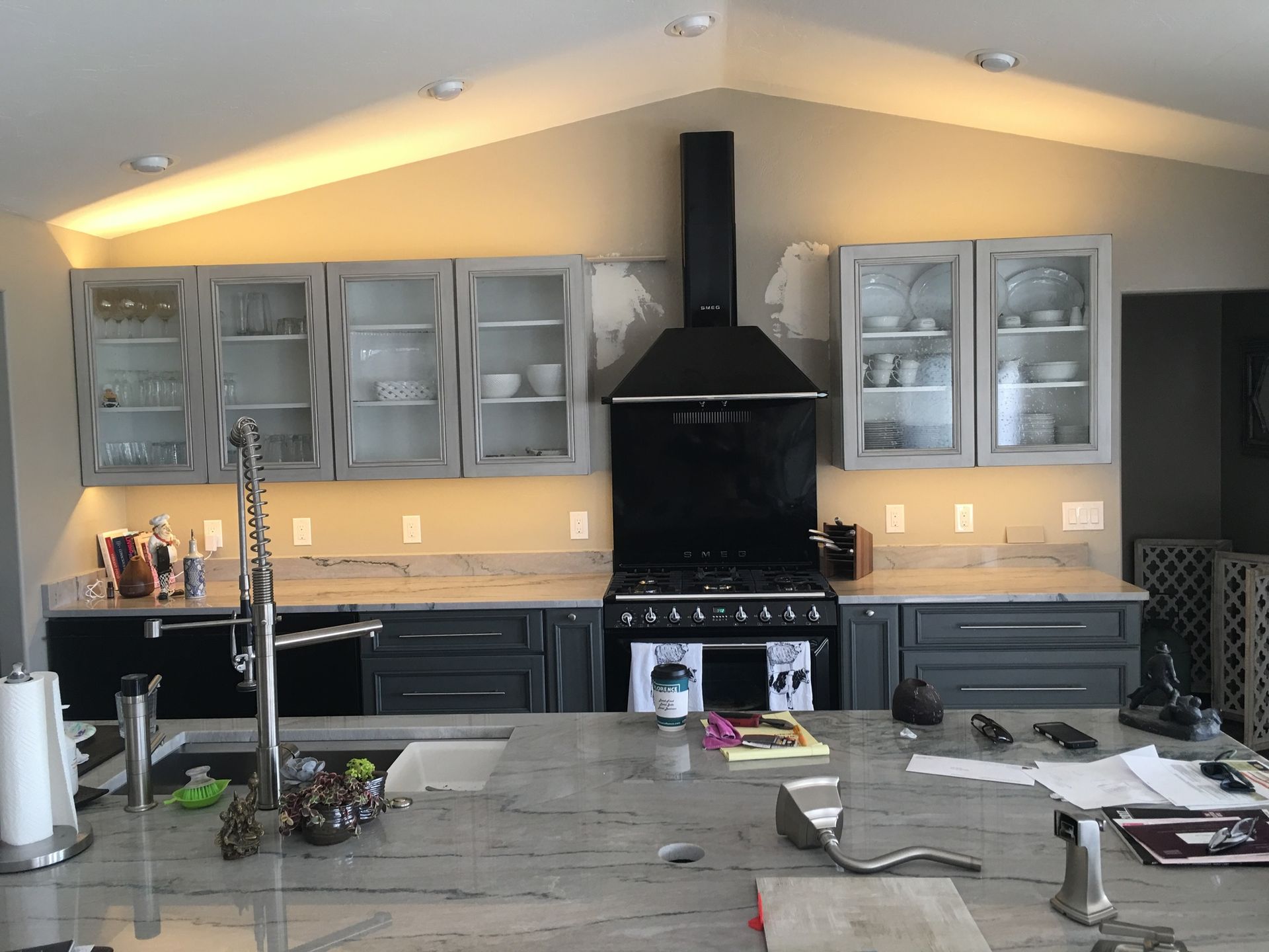 A kitchen with a stove , sink , and cabinets