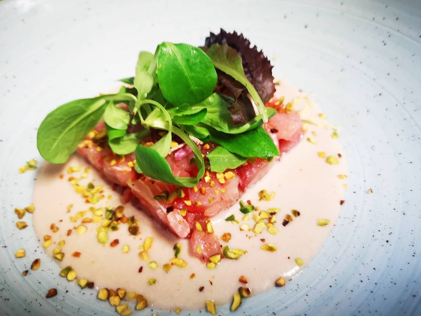 Piatto di melanzane con vino e vaso a forma di testa siciliana.