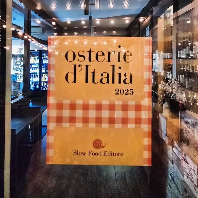 Piatto di melanzane con vino e vaso a forma di testa siciliana.