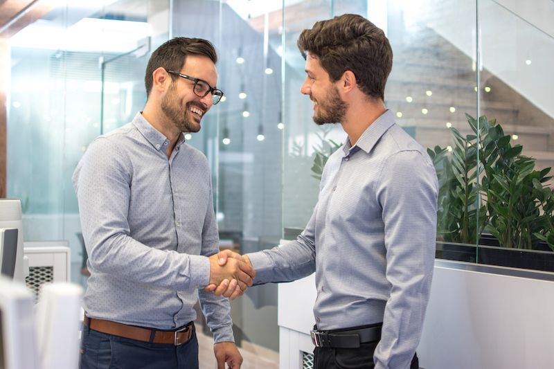 handshake in an office building between two men