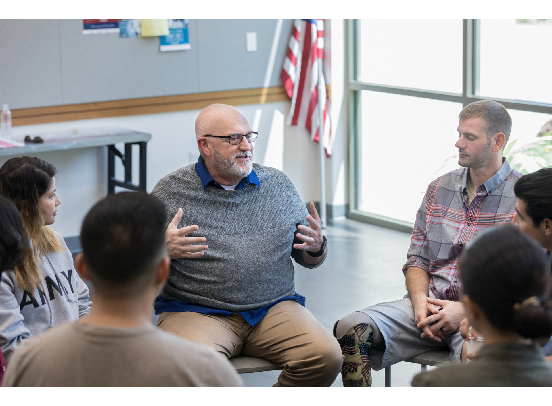 A group of people are sitting in a circle talking to each other.