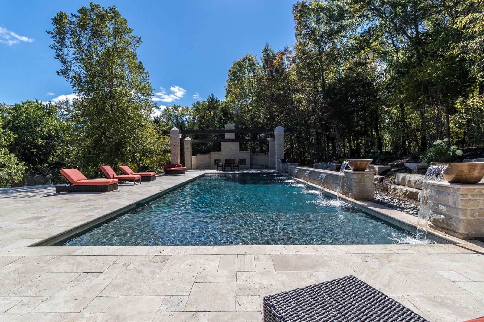 A large swimming pool surrounded by chairs and trees