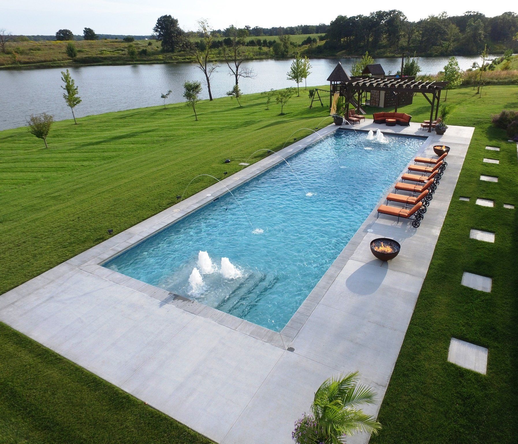 An aerial view of a large swimming pool next to a lake