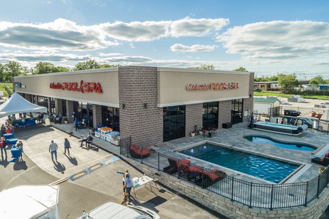 An aerial view of a building with a swimming pool in front of it.