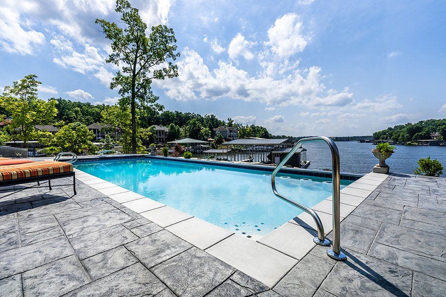 A large swimming pool with a view of a lake.