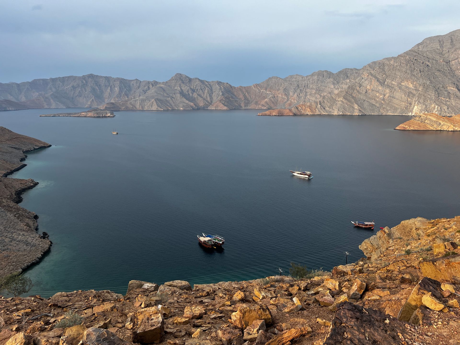 Aerial view of Musandam fjords with turquoise waters and rocky cliffs near Khasab during a Musandam Trip.