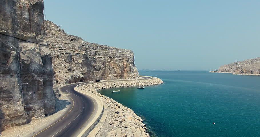 Beautiful coastal road from Dubai to Khasab with turquoise waters and rugged cliffs along the Musandam Peninsula.