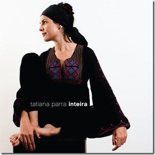 Tatiana parra inteira está sentada em uma cadeira com as pernas cruzadas