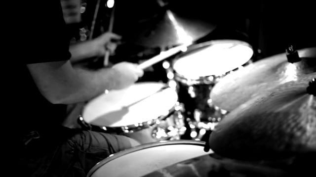 Um homem tocando bateria em uma foto em preto e branco