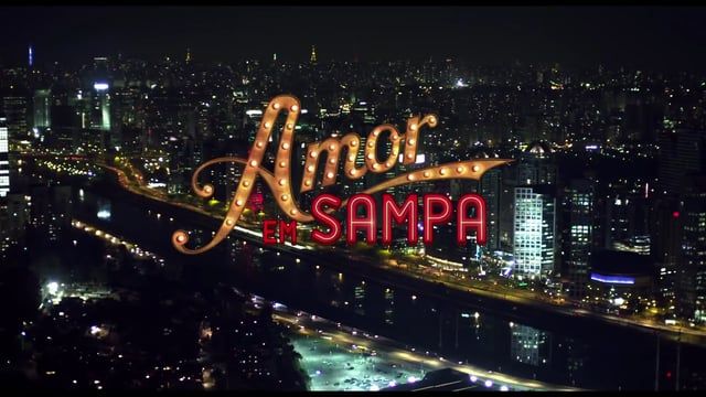 Uma vista aérea de uma cidade à noite com uma placa que diz amor sampa