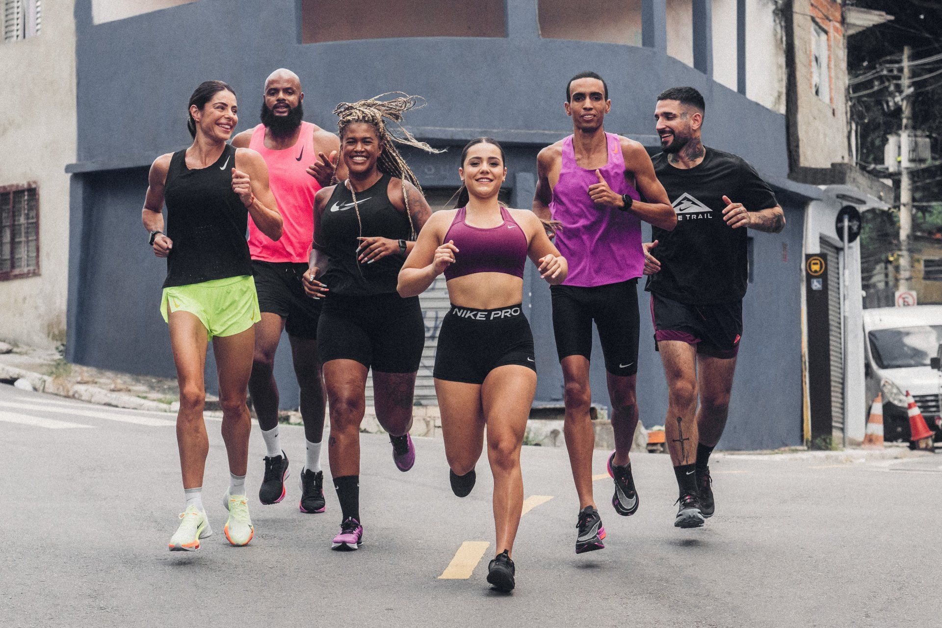 Um grupo de pessoas está correndo por uma rua.