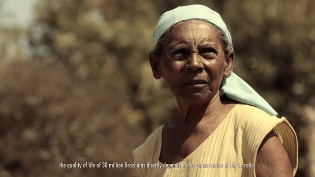 Uma mulher mais velha usando um lenço na cabeça e uma camisa amarela