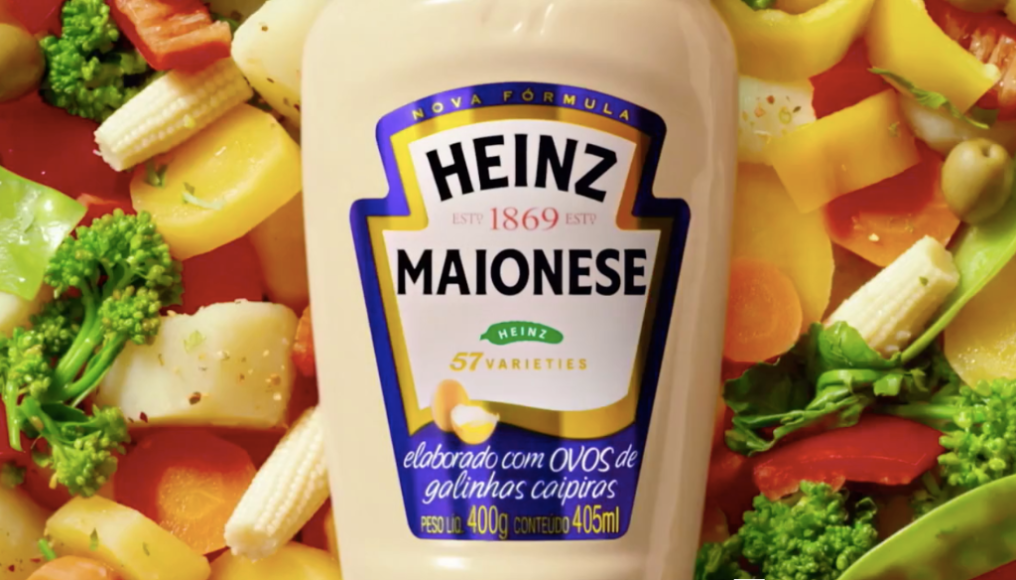 Uma garrafa de maionese heinz está rodeada de vegetais