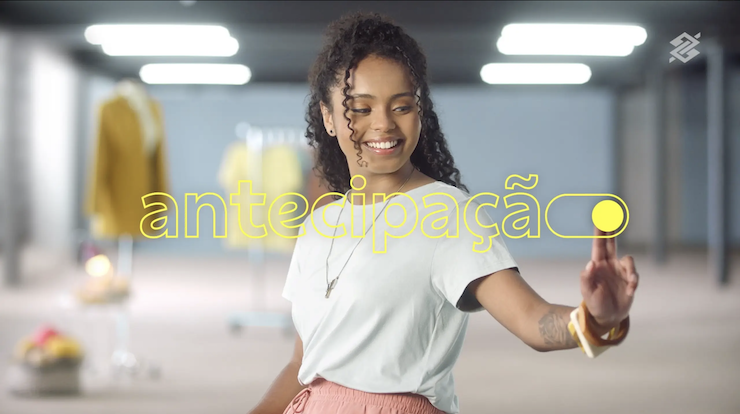 Uma mulher de camisa branca e saia rosa está dançando em uma loja.