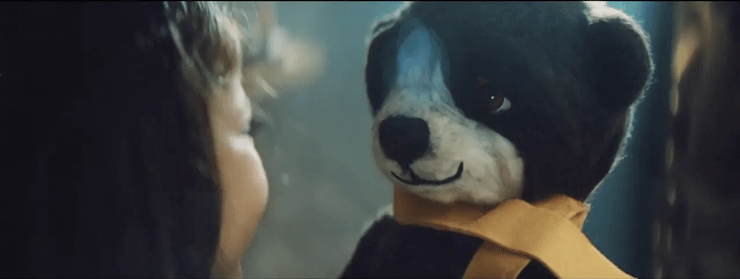 Uma mulher está acariciando um cachorro de pelúcia na frente de um espelho.