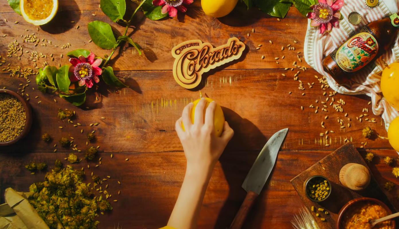 Uma pessoa está cortando um limão em uma mesa de madeira.