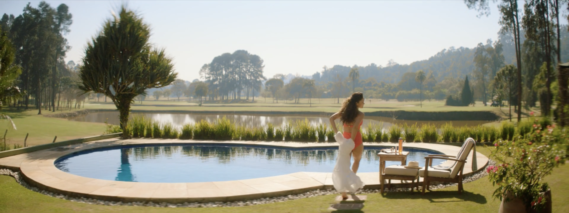 Uma mulher está parada em frente a uma grande piscina.