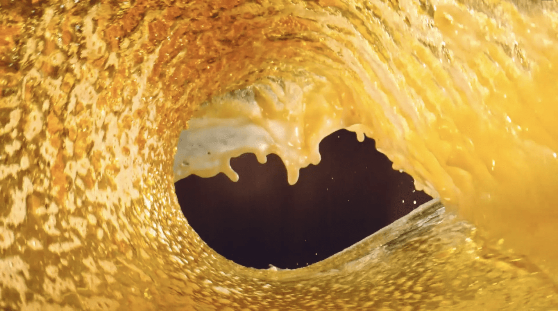 Um close de uma onda no oceano com um buraco no meio.