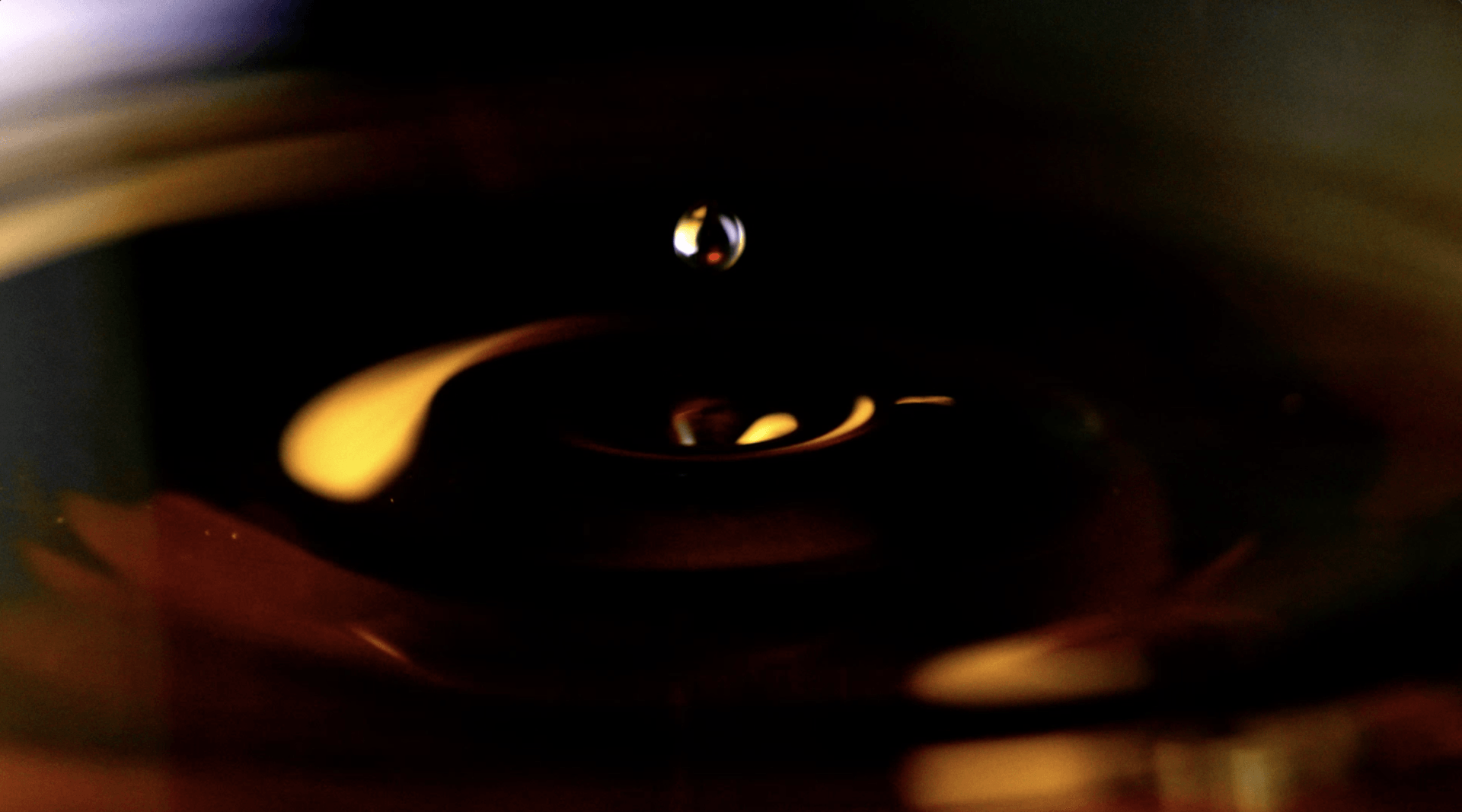 Um close de uma gota de líquido em um quarto escuro.