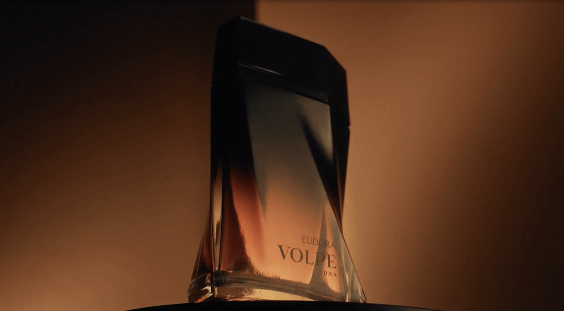 Um frasco de perfume está sobre uma mesa em um quarto escuro.