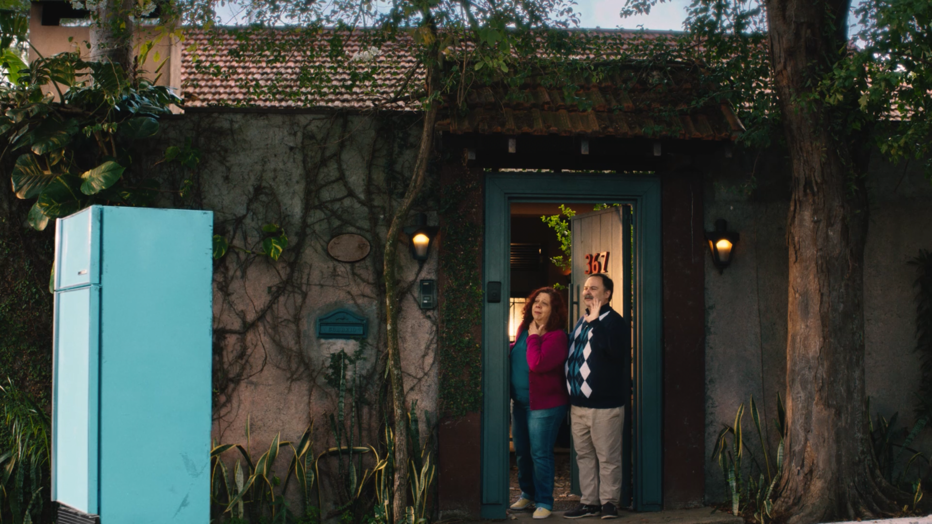 Um homem e uma mulher estão parados na frente de uma casa.