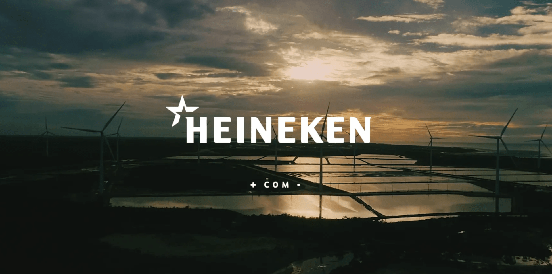 Uma vista aérea de um logotipo da Heineken com moinhos de vento ao fundo.