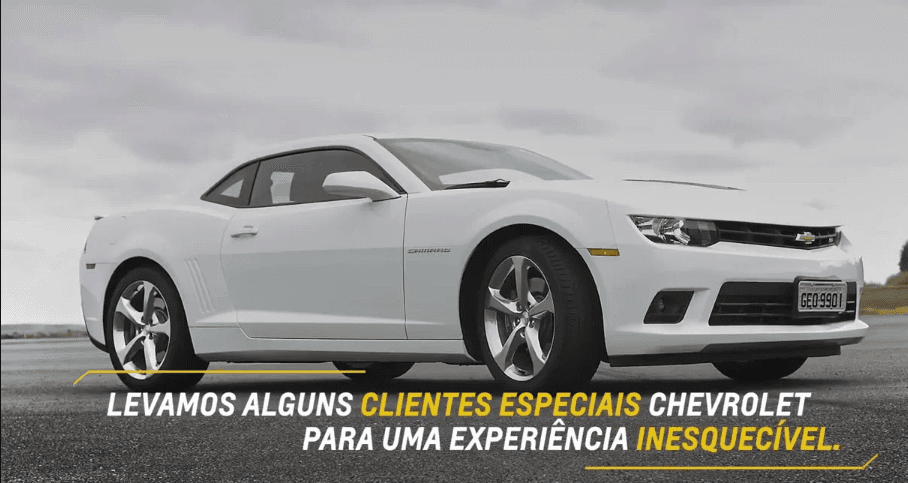 Um chevrolet camaro branco está estacionado na beira da estrada