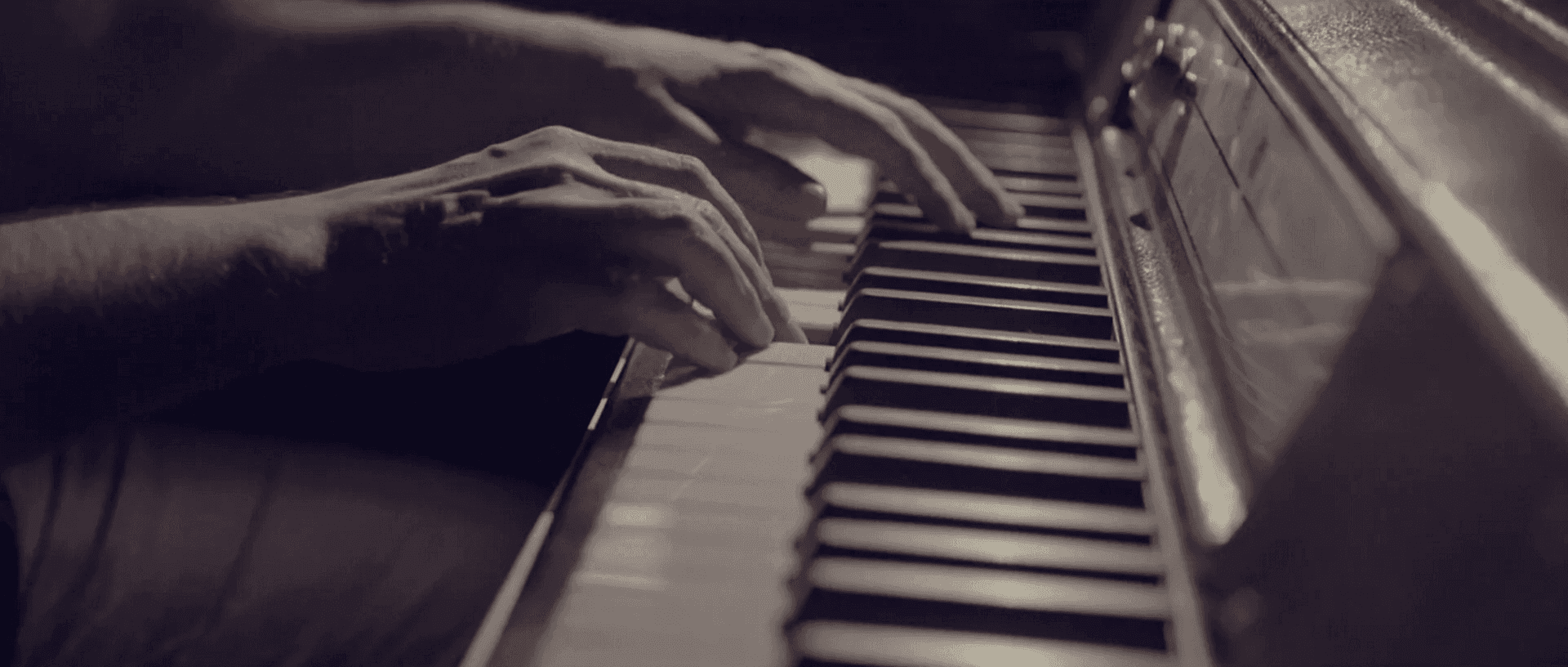 Uma pessoa está tocando piano em uma foto em preto e branco.