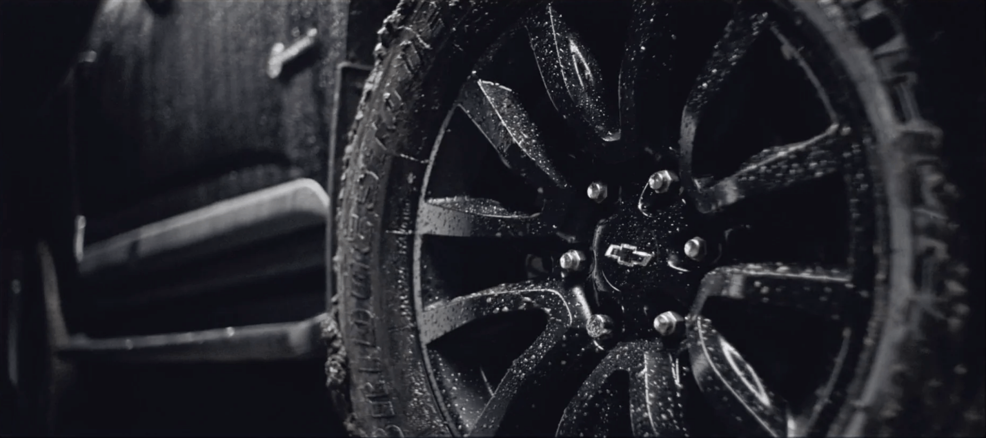 Um close de uma roda de carro com gotas de água.