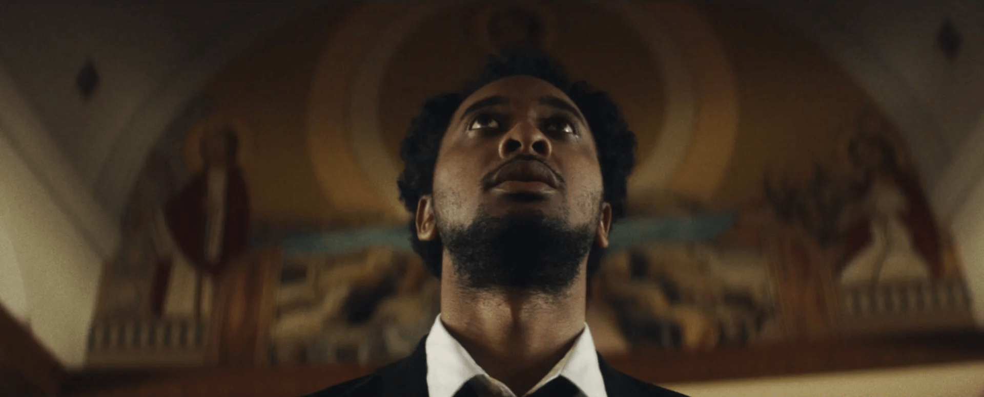 Um homem de terno e gravata está olhando para o teto.