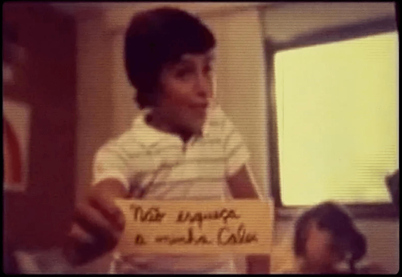 A young boy is holding a piece of paper that says 