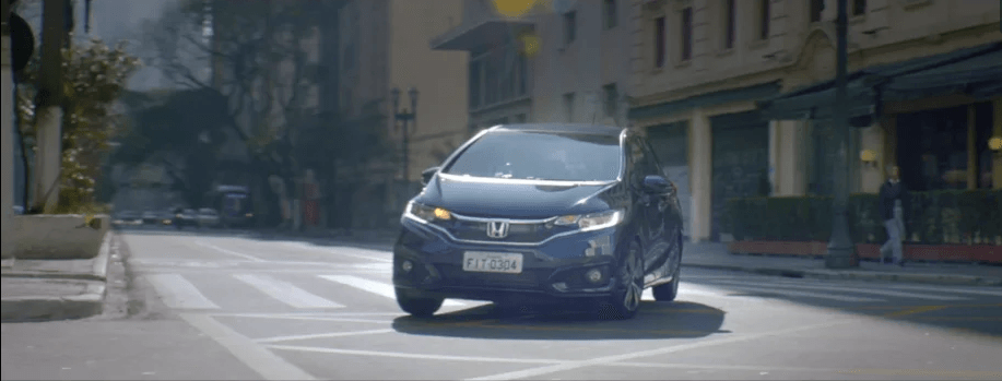 Um carro está passando por uma rua da cidade.
