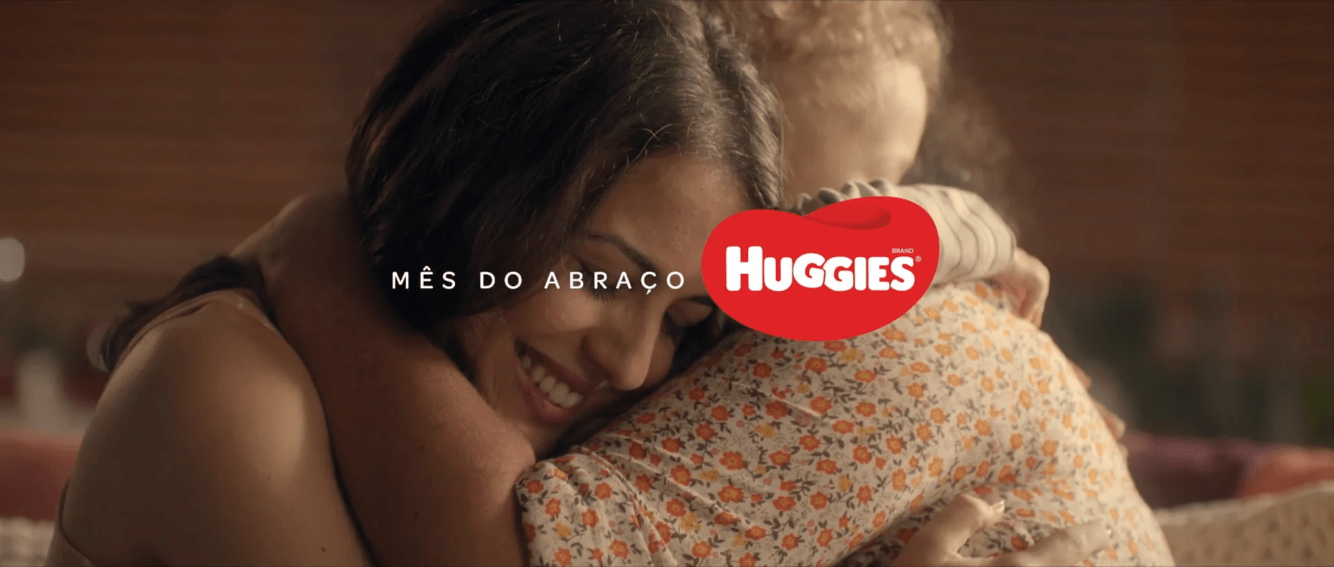 Uma mulher está abraçando um bebê em um anúncio de abraços.