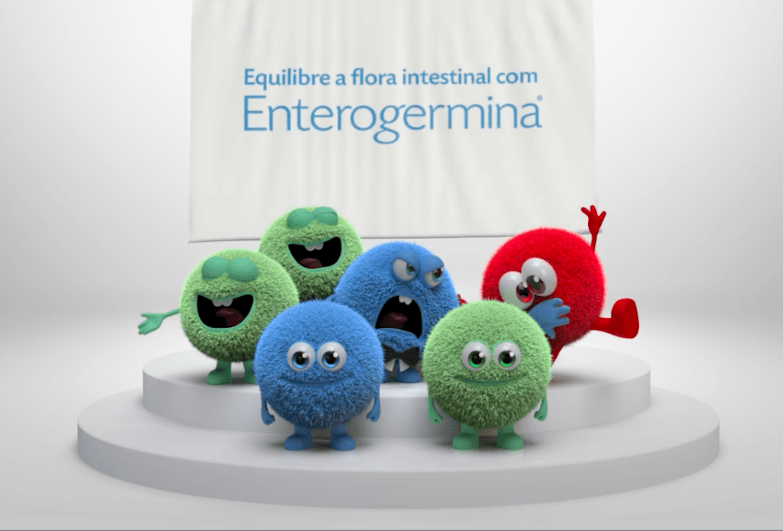 Um grupo de bichos de pelúcia está em um pódio em frente a uma placa que diz enterogermina