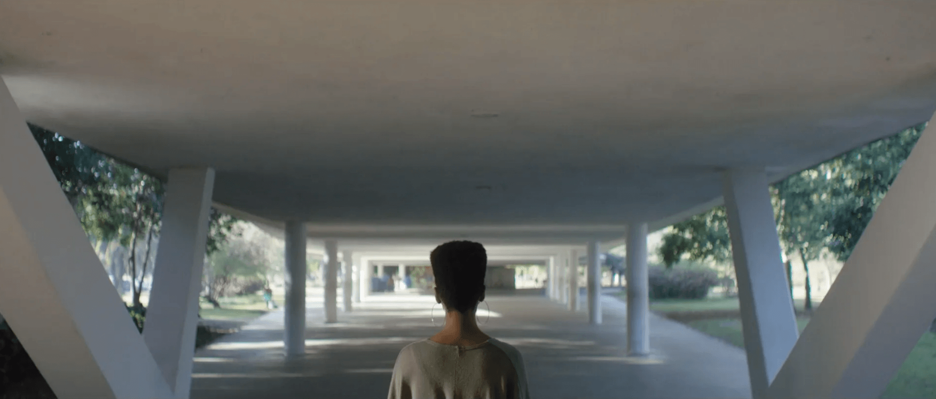 Um homem está andando por um túnel em um prédio.