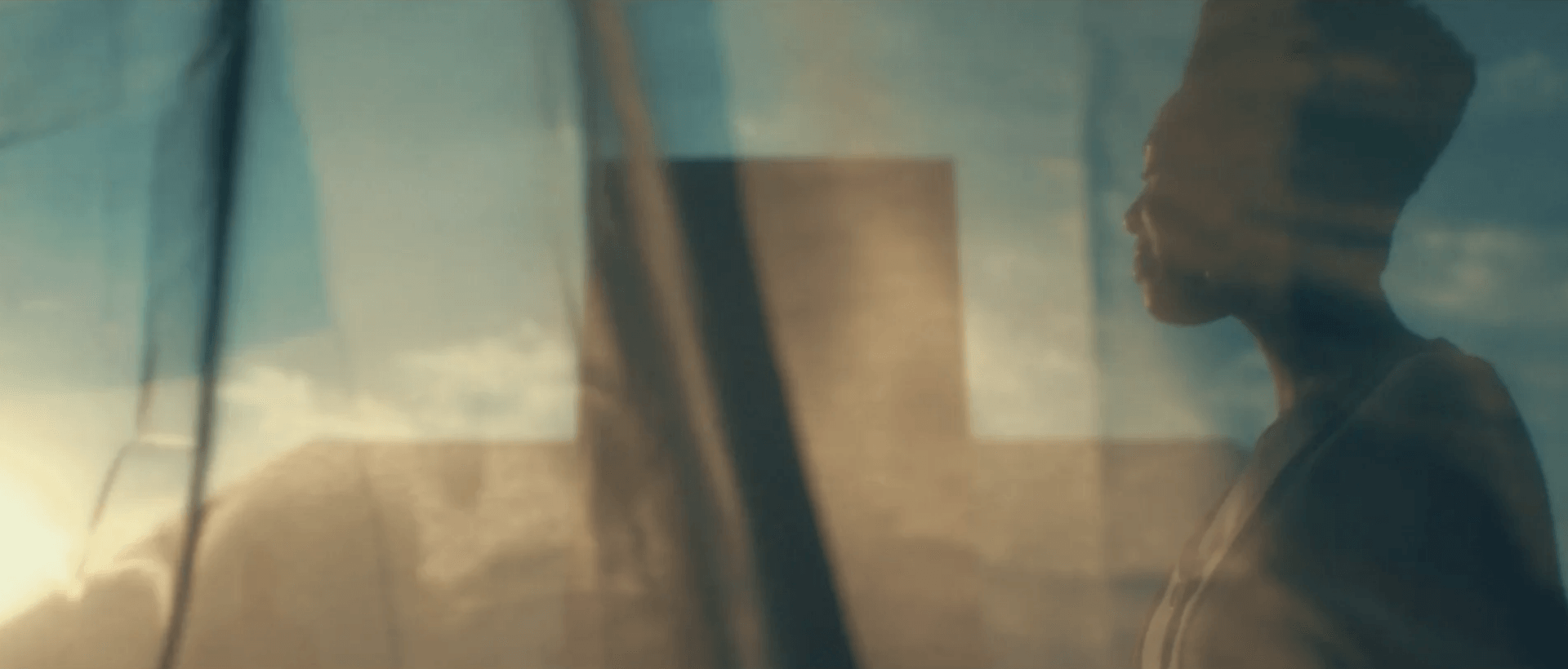 Uma mulher está parada em frente a uma janela olhando para fora.