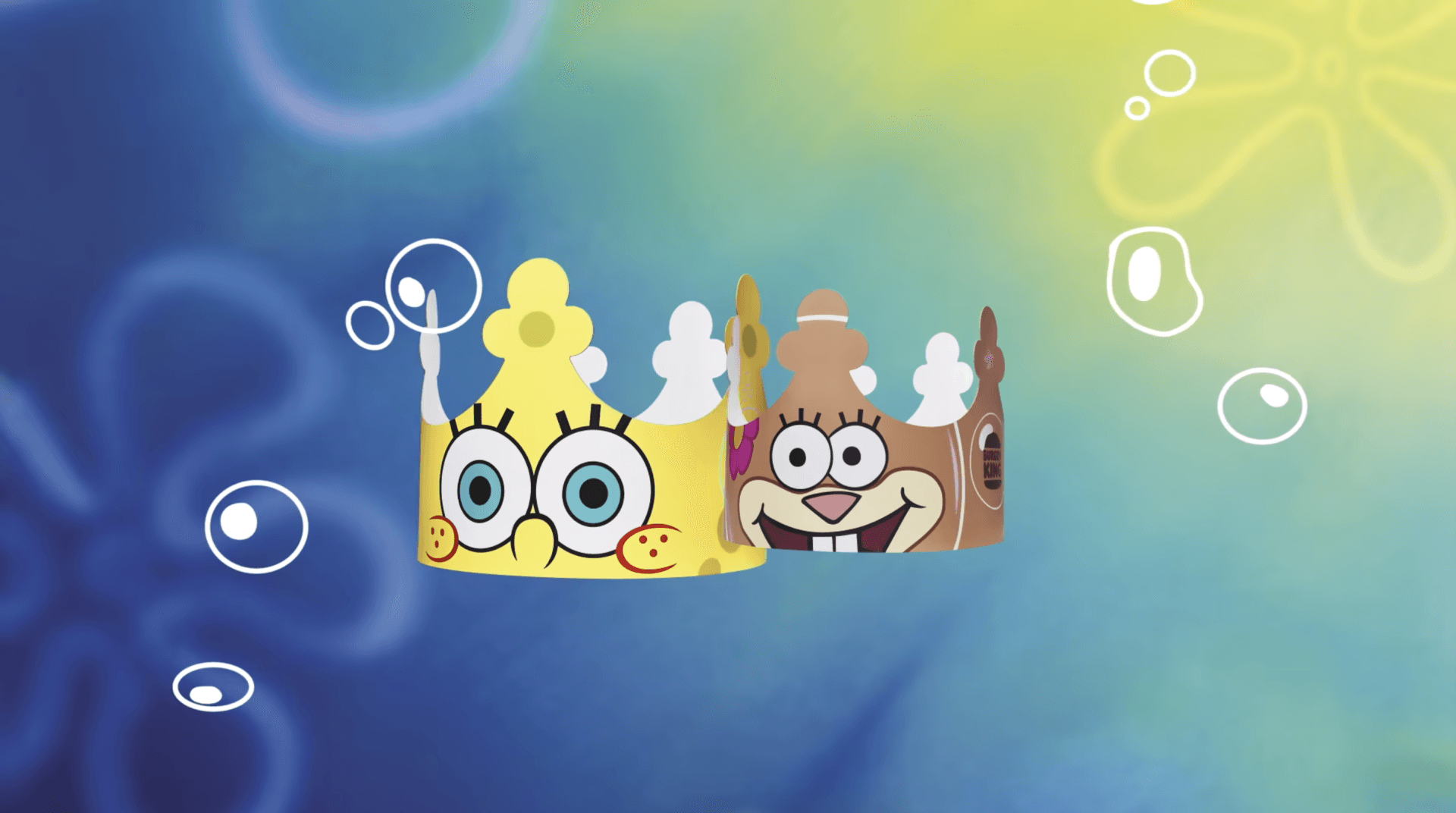 Bob Esponja e bochechas arenosas estão usando coroas de papel em um fundo azul.