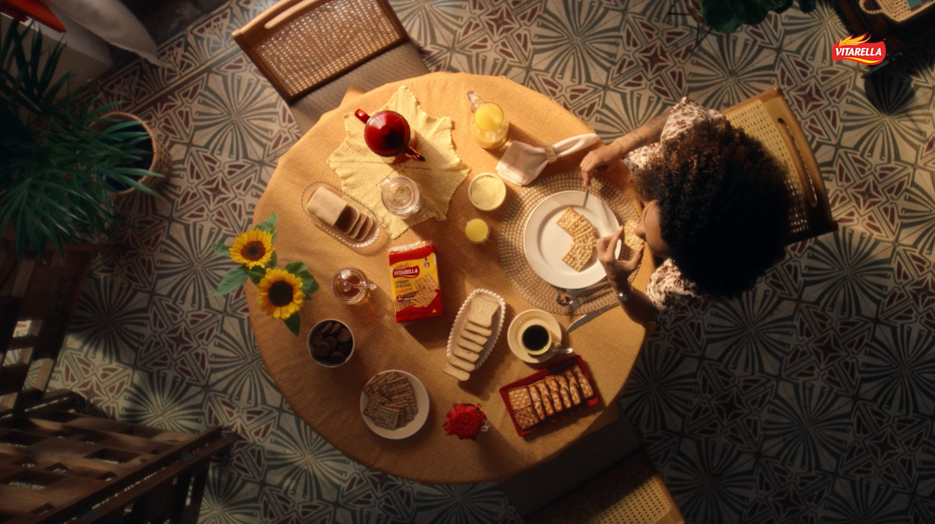 Uma mulher está sentada a uma mesa com um prato de comida.
