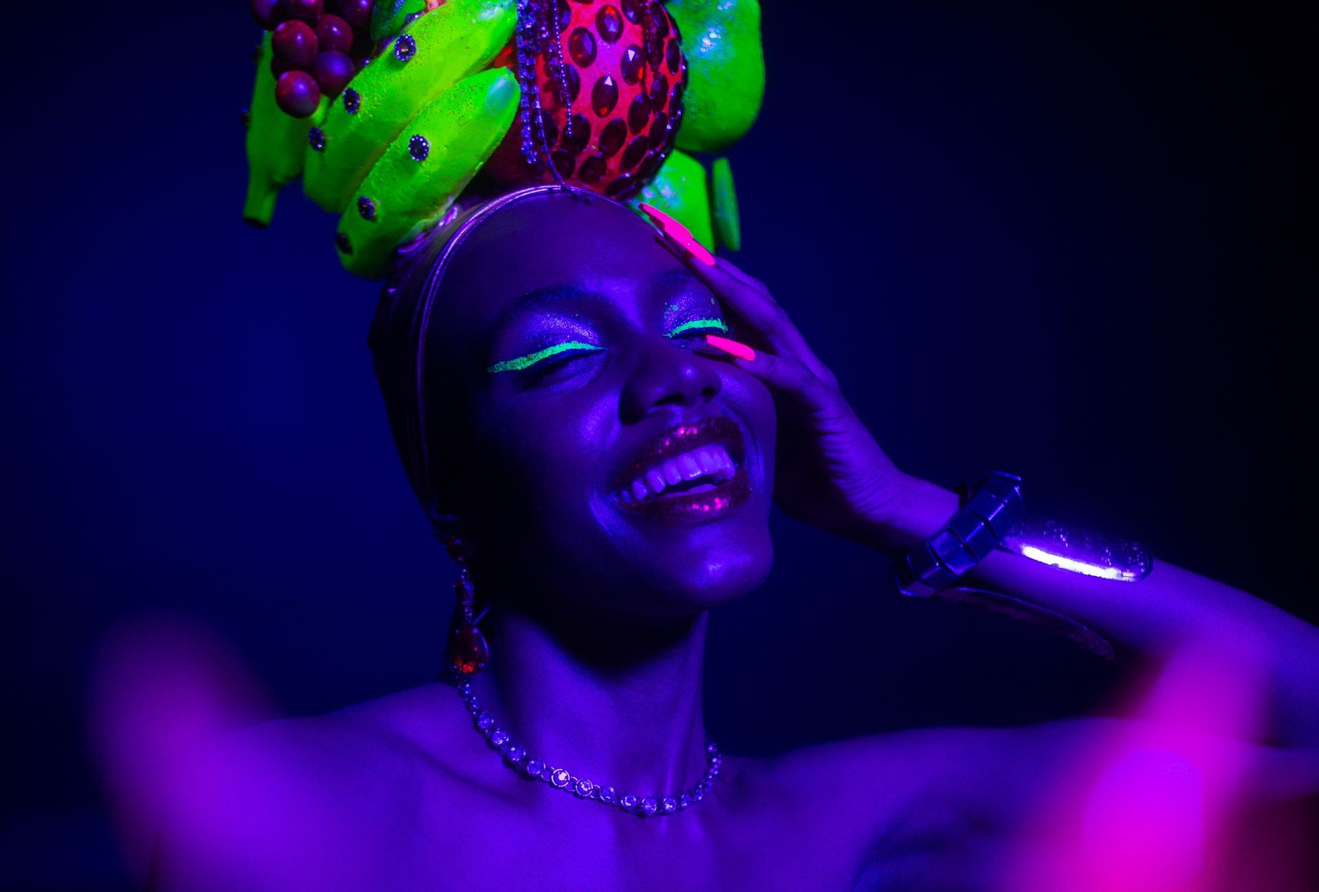 Uma mulher está usando um capacete colorido e maquiagem que brilha no escuro.