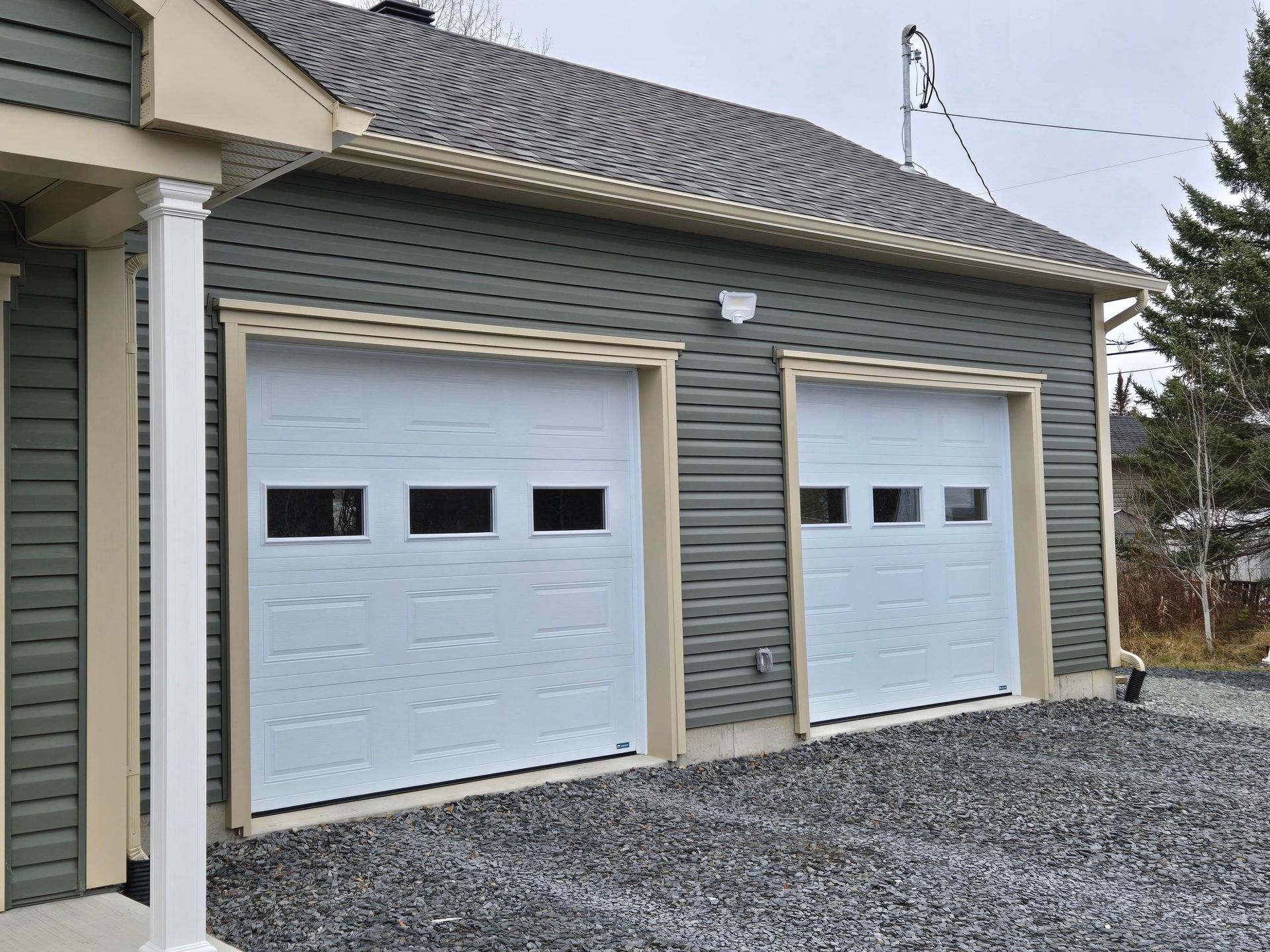 Il y a deux portes de garage sur le côté d'une maison.