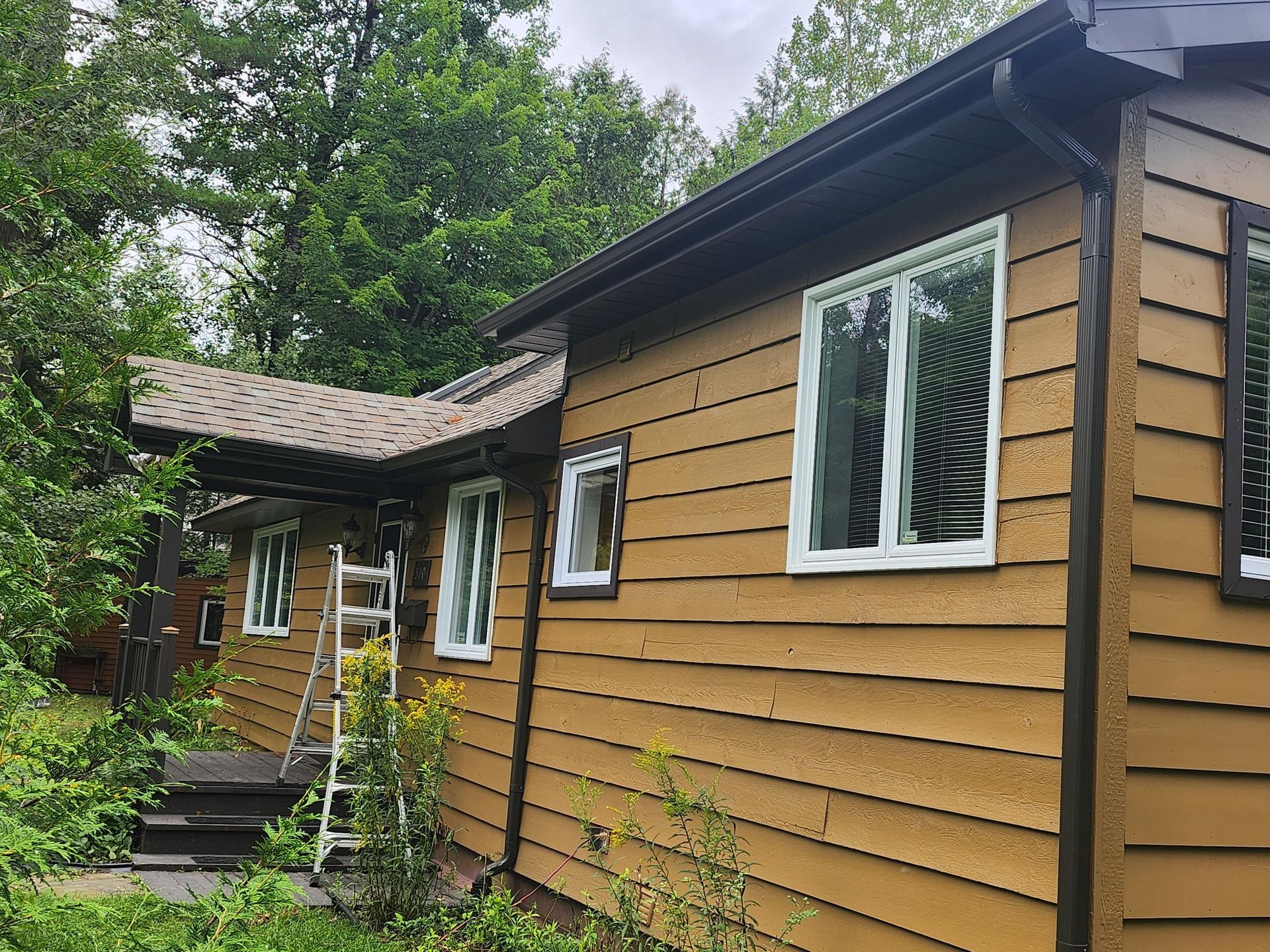 Une maison jaune avec une échelle sur le côté.