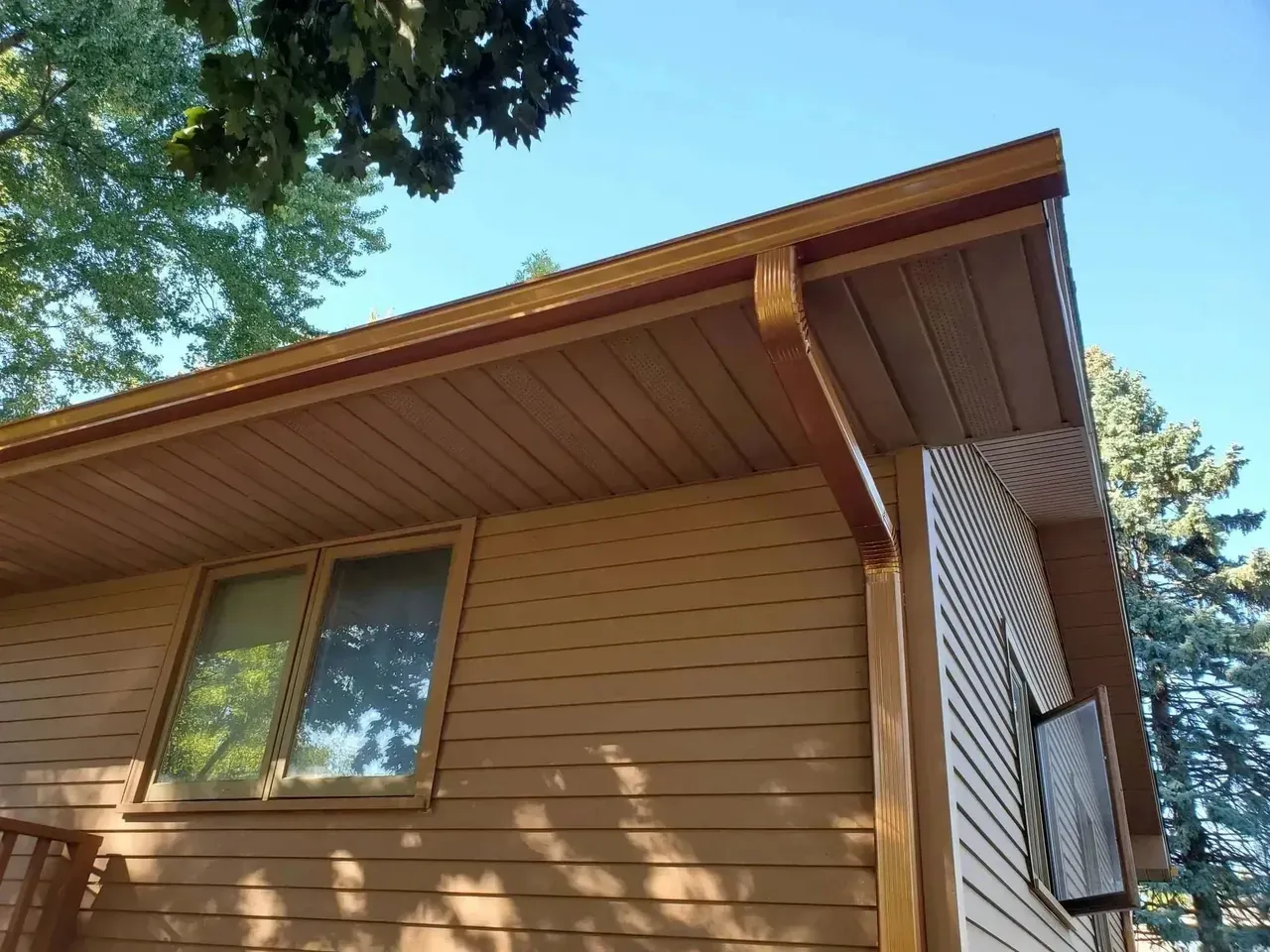 Une maison avec une gouttière sur le côté et une fenêtre.