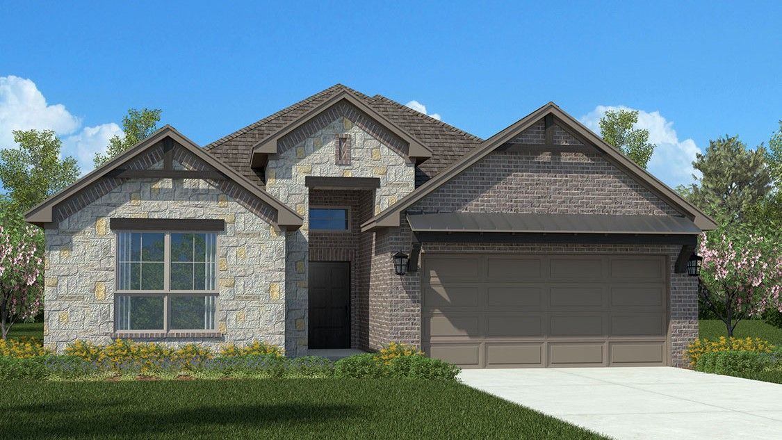 Stone-clad house with a gabled roof, two car garage, and manicured lawn against a bright blue sky.