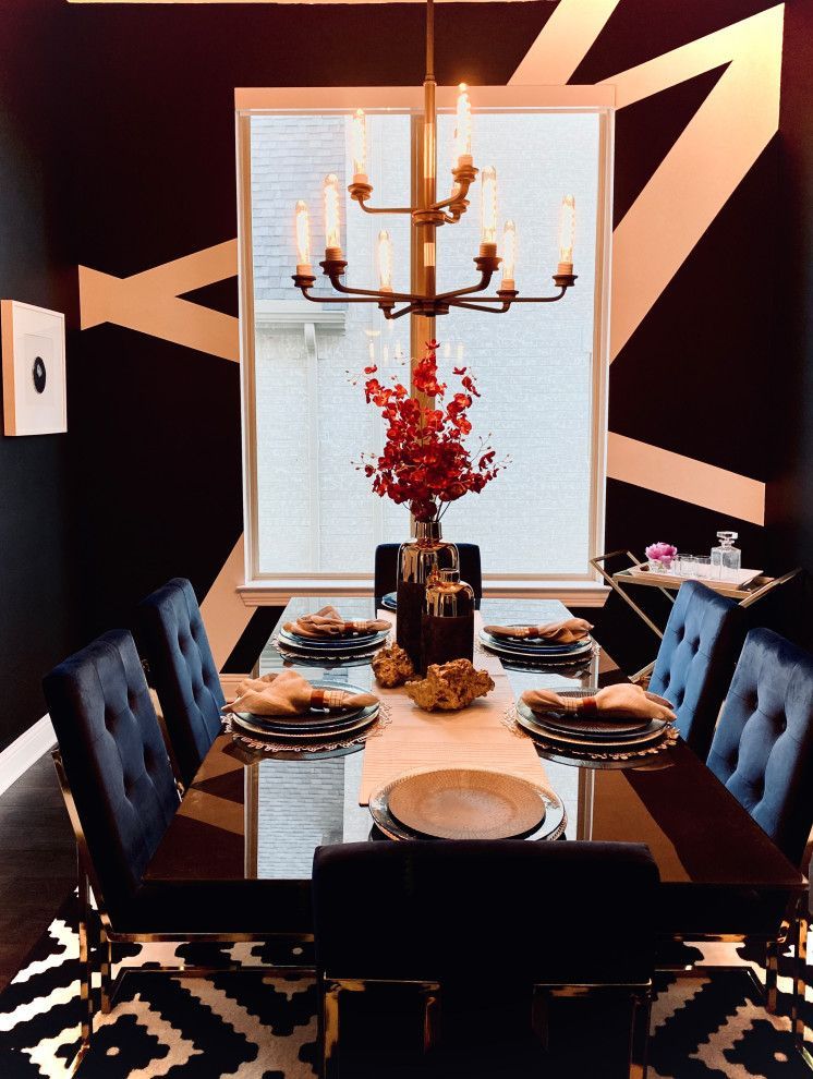 Formal dining room with black walls and gold geometric design, centered around a table set for a meal.