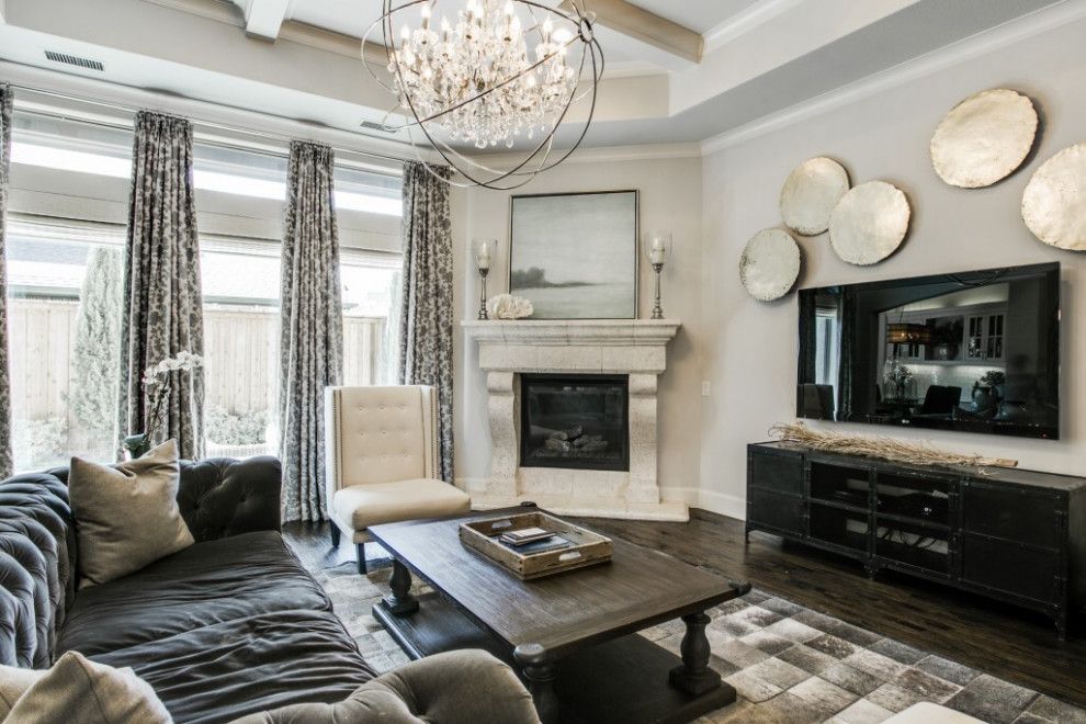 Living room with a fireplace, dark gray sofa, and decorative wall mirrors.