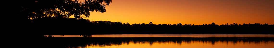 A Sunset Over a Lake with Trees