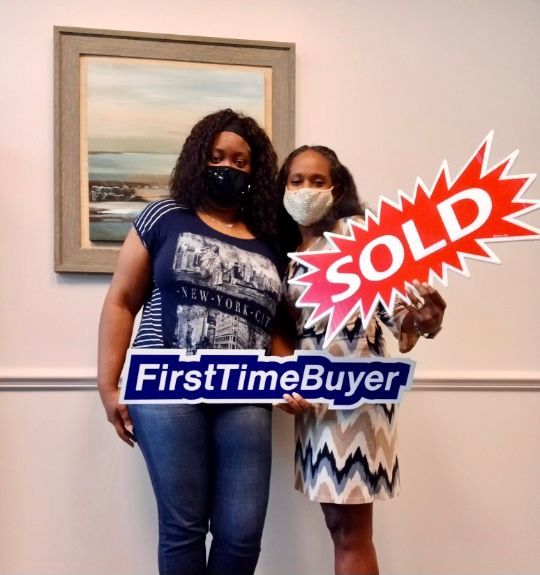 A dining room with a table and chairs and a wooden staircase.