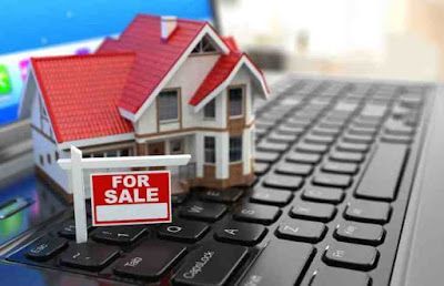 A model house is sitting on top of a laptop keyboard.